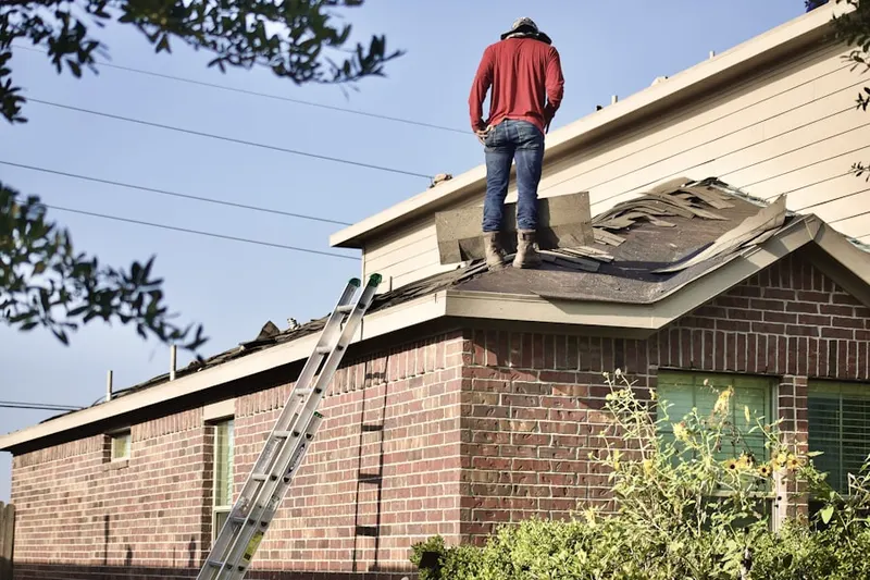 Professional roofer working on a residential roof in West Goshen